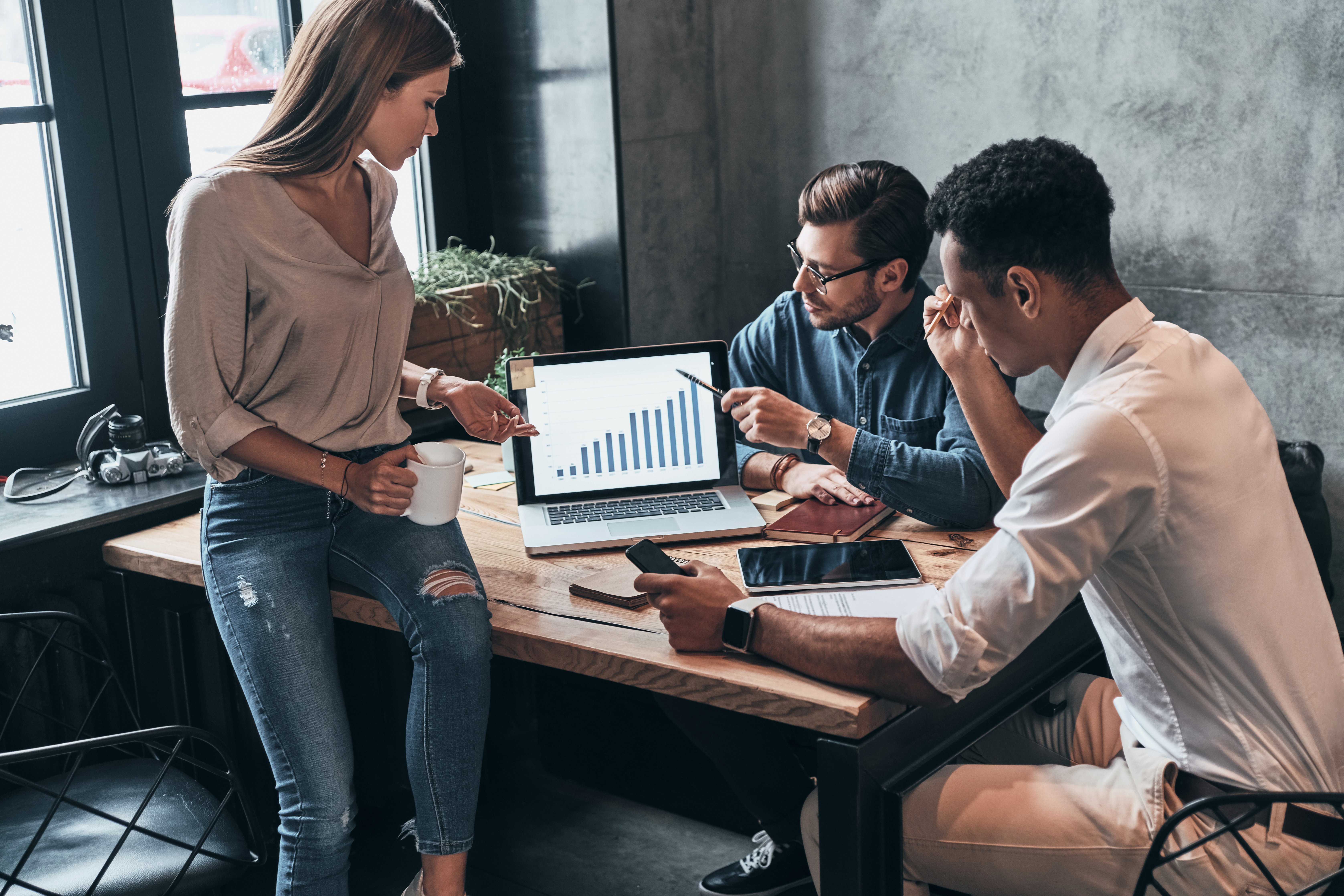  Co-workers assess business spending cost using AI-generated data analytics.
