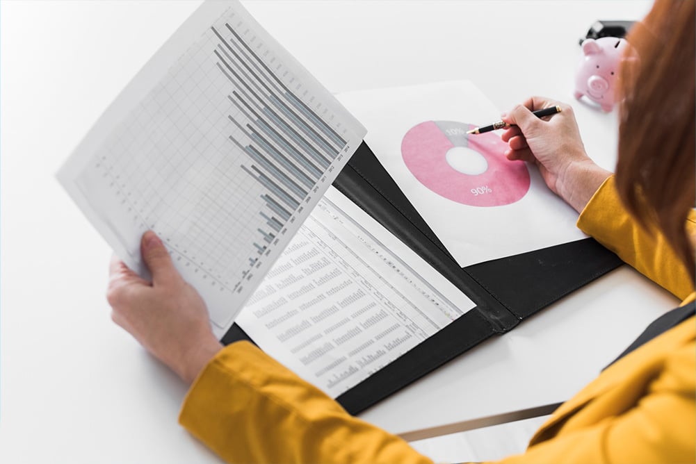 Business professional analyzing bar and pie charts to uncover hidden procurement spend, illustrating the importance of tail-end spend visibility and data-driven decision-making.